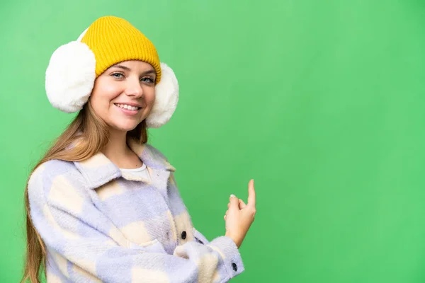 年轻的金发女人披着冬衣 背对着孤零零的彩色背景 — 图库照片