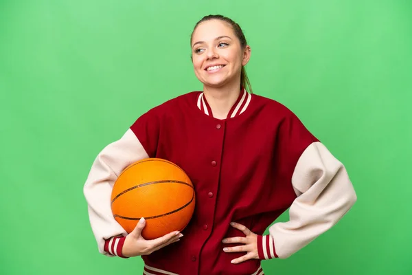 年轻的金发女子在孤零零的彩色关键背景上打篮球 手挽手 面带微笑 — 图库照片