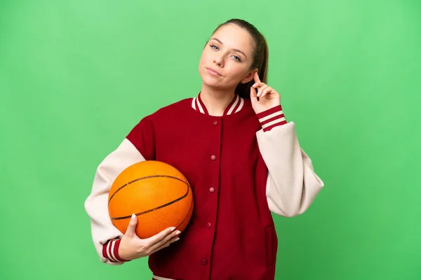 若いですブロンド女性プレイバスケットボール上の隔離されたクロマキー背景持っています疑問 — ストック写真