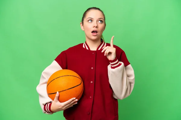 年轻的金发女子在孤立的有色人种背景下打篮球 想办法指指点迷津 — 图库照片
