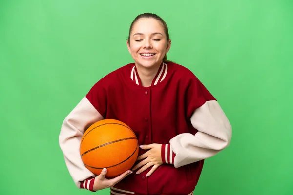 年轻的金发女子在孤零零的彩色背景下打篮球 面带微笑 — 图库照片