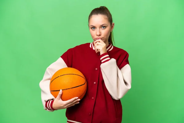 若いですブロンド女性プレイバスケットボール上の隔離されたクロマキー背景思考 — ストック写真