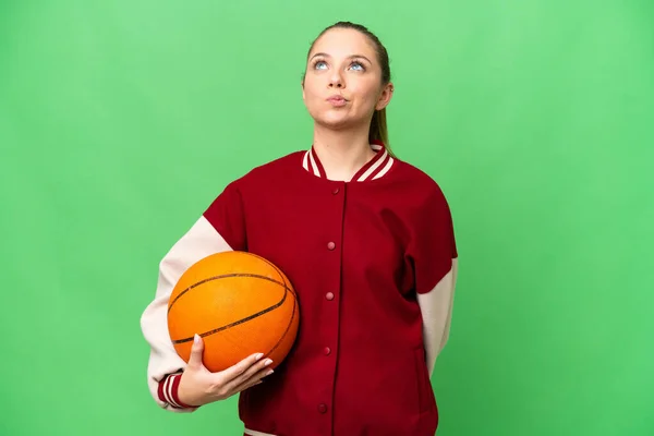若いですブロンド女性プレイバスケットボール上の隔離されたクロマキー背景と見上げます — ストック写真