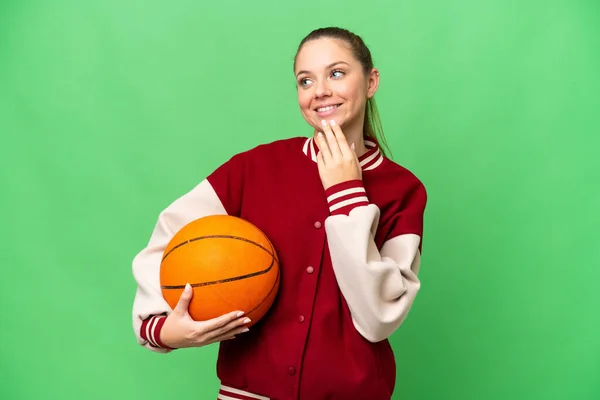 Młoda Blondynka Gra Koszykówkę Odizolowanym Tle Chroma Key Patrząc Górę — Zdjęcie stockowe
