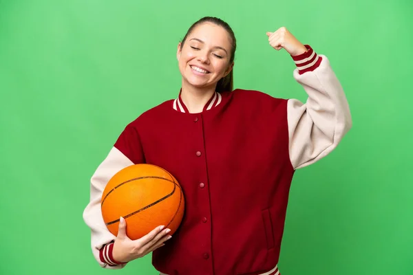 年轻的金发女子在孤立的有色人种背景下打篮球 做着强有力的手势 — 图库照片