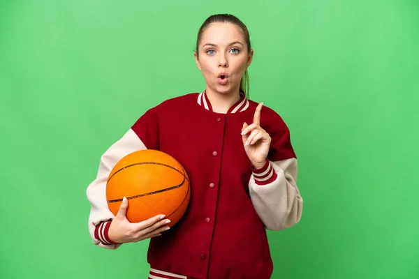 若いですブロンド女性プレイバスケットボール上の隔離されたクロマキー背景意図すると解決策を実現する指を持ち上げながら — ストック写真