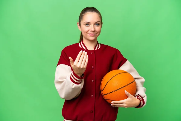 孤立したクロマキーの背景にバスケットボールをしている若いブロンドの女性が手で来るように誘う 来てくれて嬉しい — ストック写真
