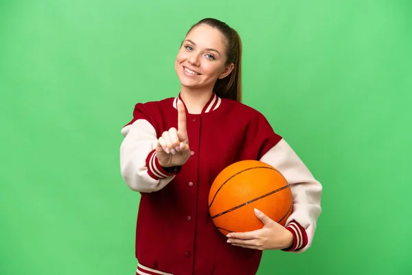 若いですブロンド女性プレイバスケットボール上の隔離されたクロマキー背景ショーと持ち上げる指 — ストック写真