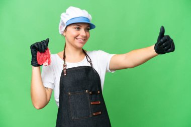 Kasap kadın önlük takıyor ve izole edilmiş krom anahtar arka planda taze et servis ediyor.