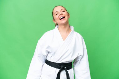 Karate yapan genç sarışın kadın izole edilmiş krom anahtar arka planda gülüyor.