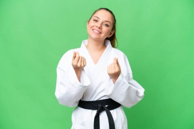 Karate yapan genç sarışın kadın izole edilmiş krom anahtar arka planda para hareketi yapıyor.