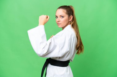 Tecrit edilmiş krom anahtar geçmişi olan genç sarışın kadın karate yapıyor.