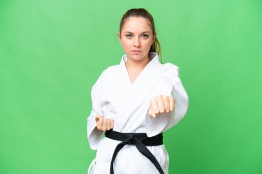 Tecrit edilmiş krom anahtar geçmişi olan genç sarışın kadın karate yapıyor.