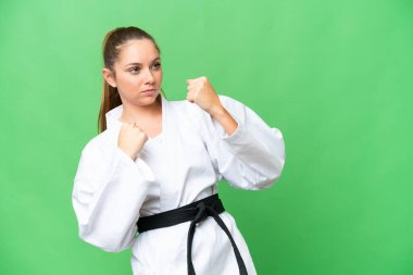 Tecrit edilmiş krom anahtar geçmişi olan genç sarışın kadın karate yapıyor.