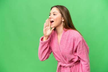 Bornozlu genç bir kadın izole edilmiş krom anahtar arka planda ağzı sonuna kadar açık bağırıyor.