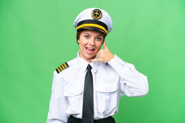 Uçak pilotu kadın izole edilmiş krom anahtar arka planda telefon jesti yapıyor. Bana geri dönüş işareti ver.