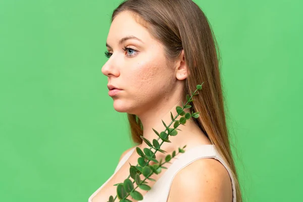 stock image Young blonde woman over isolated chroma key background holding a eucalyptus branch. Close up portrait