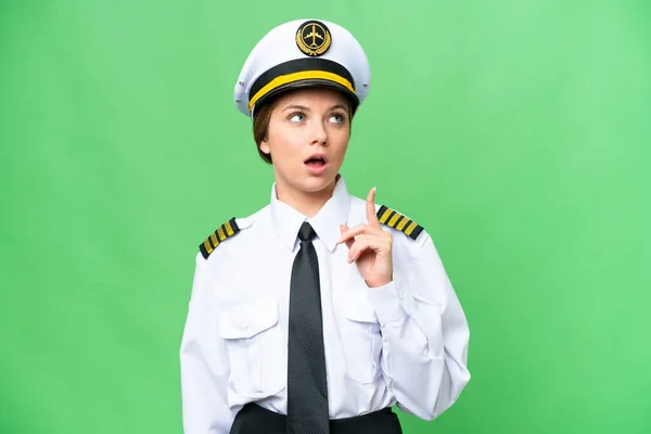 stock image Airplane pilot woman over isolated chroma key background thinking an idea pointing the finger up