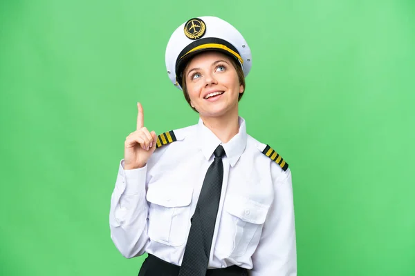 stock image Airplane pilot woman over isolated chroma key background pointing up and surprised