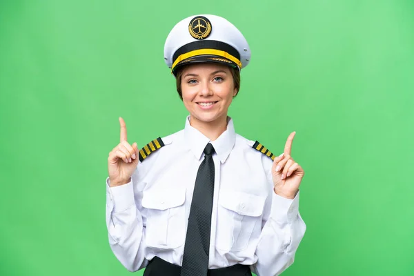 Stock image Airplane pilot woman over isolated chroma key background pointing up a great idea