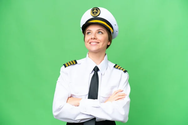 stock image Airplane pilot woman over isolated chroma key background looking up while smiling