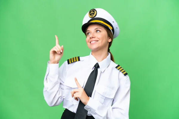Airplane pilot woman over isolated chroma key background pointing with the index finger a great idea