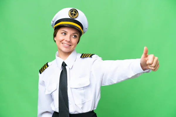 Airplane pilot woman over isolated chroma key background giving a thumbs up gesture
