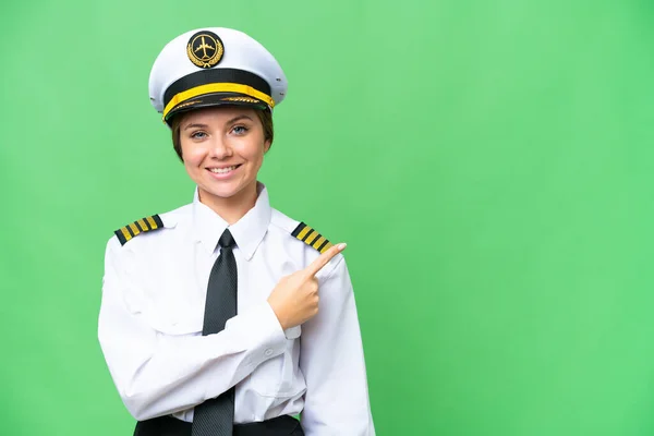 飞机驾驶员妇女通过孤立的彩色关键背景指向侧面介绍产品 — 图库照片