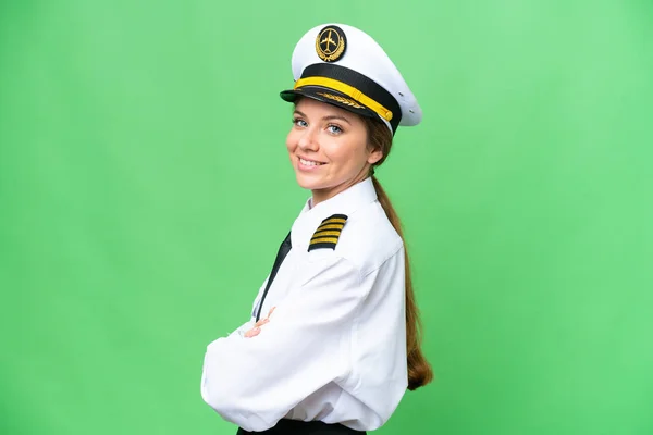 Airplane pilot woman over isolated chroma key background with arms crossed and looking forward