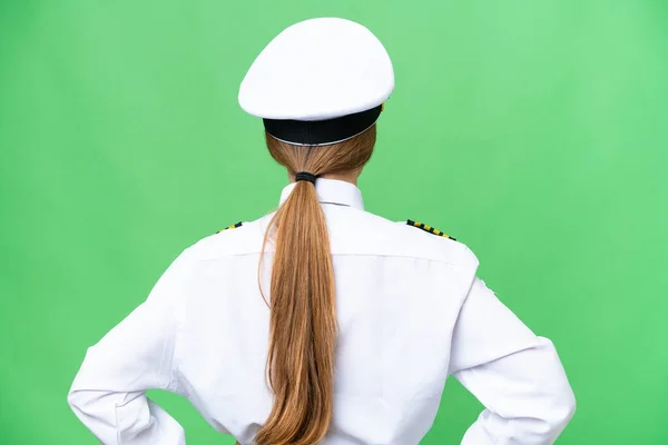 Airplane pilot woman over isolated chroma key background in back position