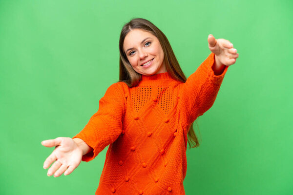 Young blonde woman over isolated chroma key background presenting and inviting to come with hand