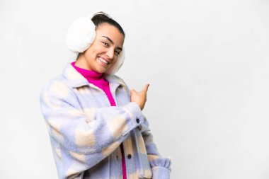 İzole edilmiş beyaz arka plan üzerinde kışlık manşetler takan genç bir kadın.