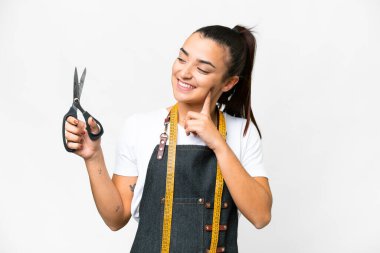 Seamstress woman over isolated white background thinking an idea while looking up