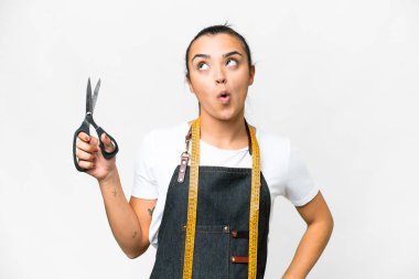 Seamstress woman over isolated white background thinking an idea pointing the finger up