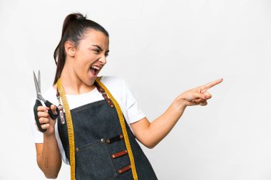 Seamstress woman over isolated white background pointing finger to the side and presenting a product