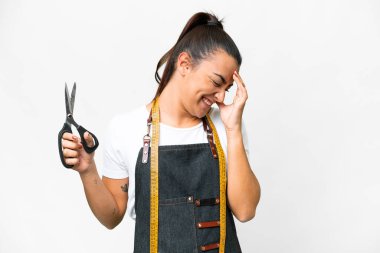 Seamstress woman over isolated white background laughing