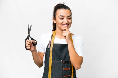 Seamstress woman over isolated white background looking to the side and smiling