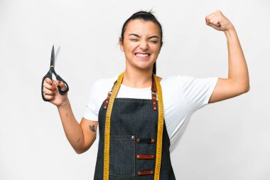 Seamstress woman over isolated white background doing strong gesture