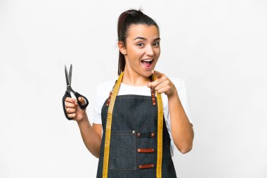 Terzi kadın izole edilmiş beyaz arka plan şaşırmış ve ön tarafı işaret ediyor.