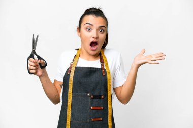 Seamstress woman over isolated white background with shocked facial expression