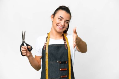 Seamstress woman over isolated white background shaking hands for closing a good deal