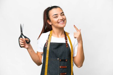 Terzi kadın, izole edilmiş beyaz arka planda baş parmak hareketi yapıyor.