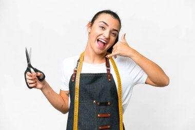 Terzi kadın izole edilmiş beyaz arka planda telefon jesti yapıyor. Bana geri dönüş işareti ver.