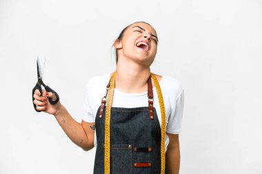 Seamstress woman over isolated white background laughing