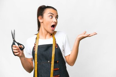 Terzi kadın, yalıtılmış beyaz arkaplan üzerinde sürpriz bir ifadeyle yan tarafa bakarken