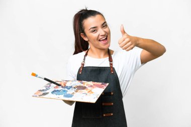 Genç sanatçı kadın iyi bir şey oldu çünkü başparmak ile izole beyaz arka plan üzerinde bir palet tutan