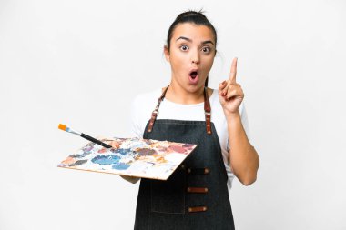 İzole edilmiş beyaz arka plan üzerinde palet tutan genç bir sanatçı kadın çözümü fark etmek için parmağını kaldırıyor.