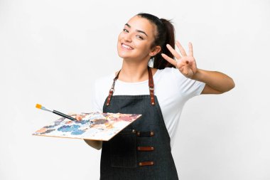 İzole edilmiş beyaz arka planda palet tutan genç sanatçı kadın mutlu ve parmaklarıyla dört tane sayıyor.