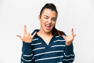 İzole edilmiş beyaz arka planda genç bir kadın boynuz hareketi yapıyor.