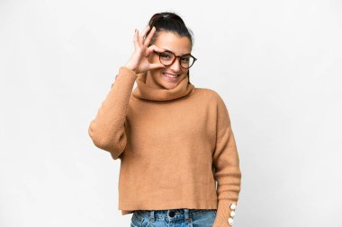 İzole edilmiş beyaz arka planda genç bir kadın parmaklarıyla işaret veriyor.